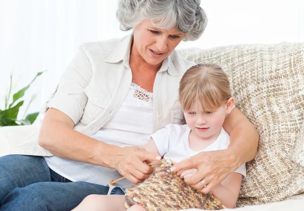 Grand-mère aidant sa petite fille à tricoter — Photo