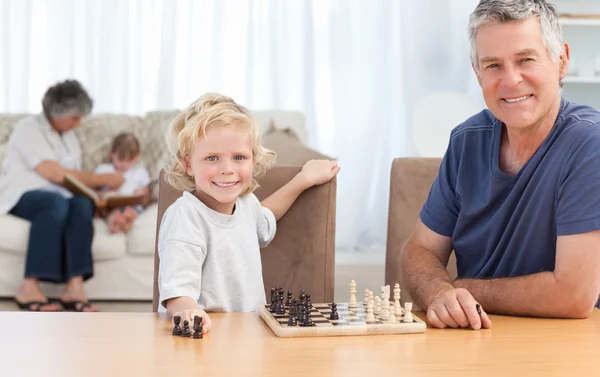 Молодий хлопчик грає в шахи зі своїм дідом — стокове фото