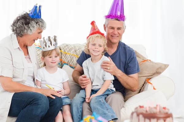 Szczęśliwe rodziny patrząc na kamery na urodziny — Zdjęcie stockowe