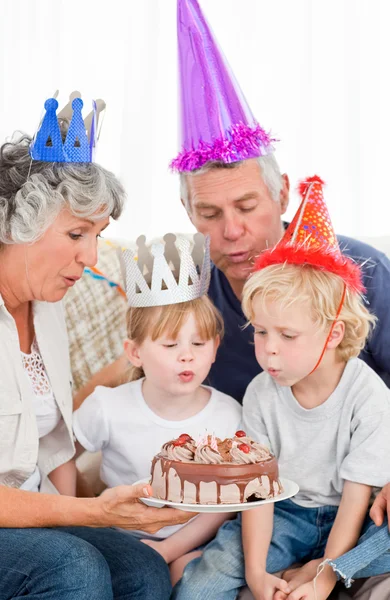 Children blowing on the birthday cake — Stock Photo, Image