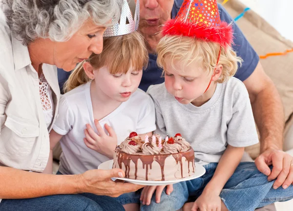 Kinder pusten auf die Geburtstagstorte — Stockfoto