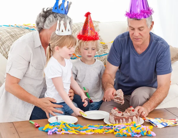 Familie isst gemeinsam die Geburtstagstorte — Stockfoto