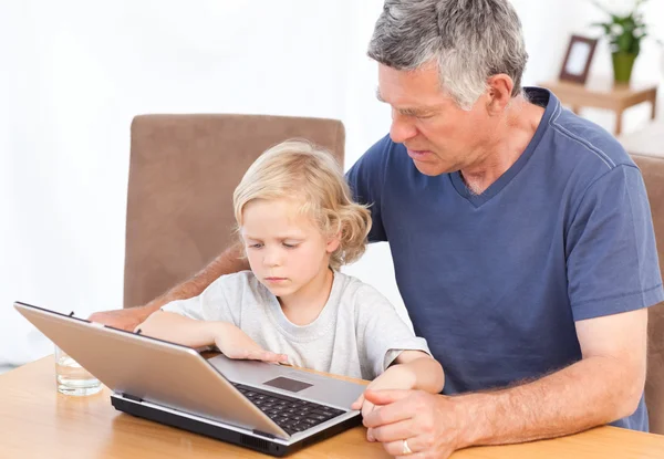 素敵な少年と彼の祖父は自分のラップトップを見て — ストック写真