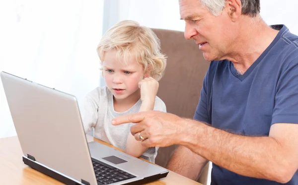 사랑 스러운 소년과 그의 할아버지는 자신의 노트북을 보고 — 스톡 사진