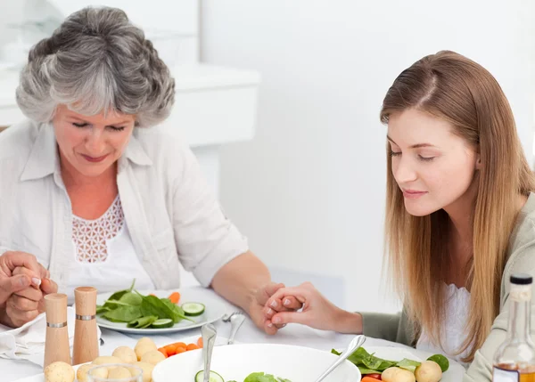 Woman and her mother praying at the table — Stock Photo, Image