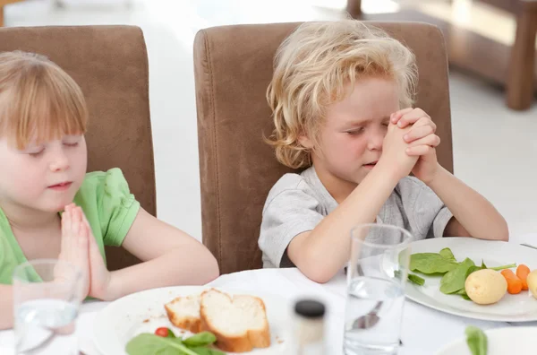 Kinderen bidden aan de tafel — Stockfoto