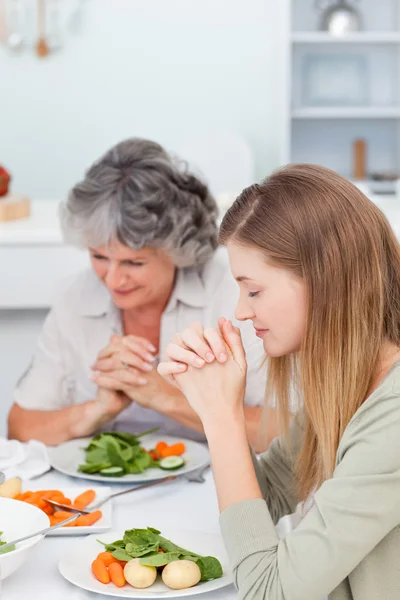 Kadın ve annesi masada dua — Stok fotoğraf