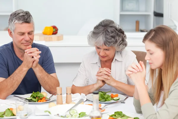 Αξιολάτρευτο οικογένεια που προσεύχεται στο τραπέζι — Φωτογραφία Αρχείου