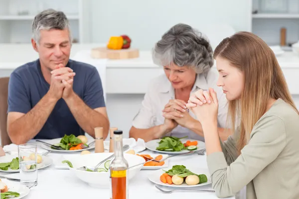 Bedårande familj be vid bordet — Stockfoto