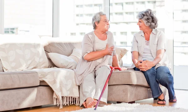 Mature friends talking on the sofa — Stock Photo, Image