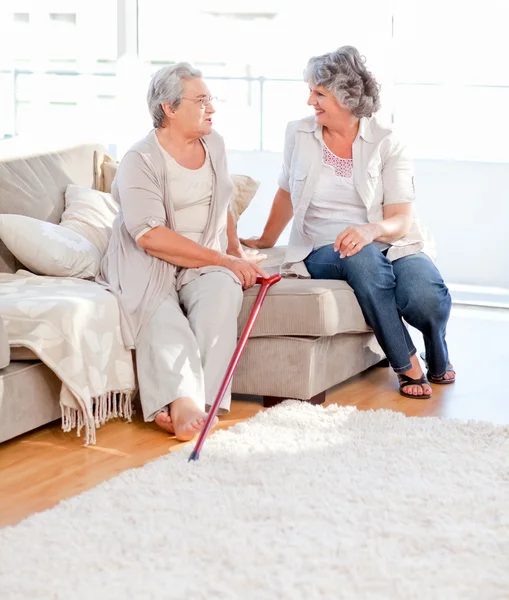 Mature friends talking on the sofa — Stock Photo, Image
