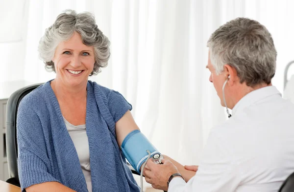 Vedoucí lékař s krevní tlak svého pacienta — Stock fotografie