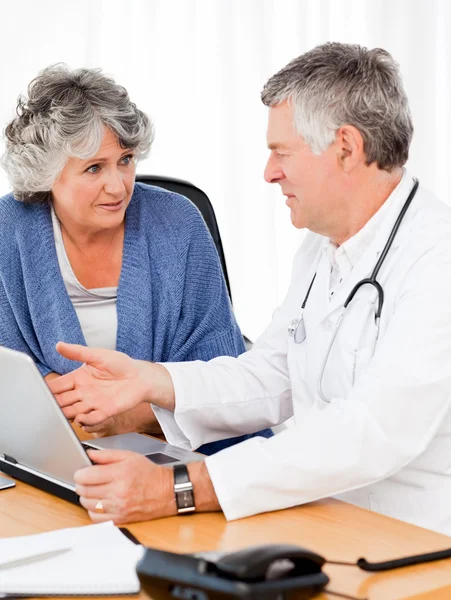Un dottore anziano con il suo paziente che guarda il portatile — Foto Stock
