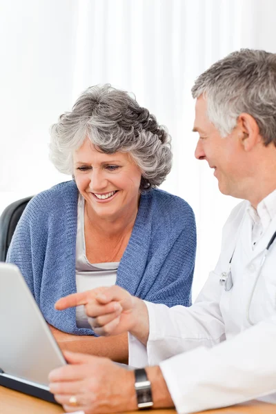 Старший врач со своим пациентом смотрит на ноутбук — стоковое фото