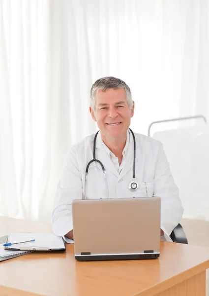 A laptop az irodájában dolgozik vezető orvos — Stock Fotó