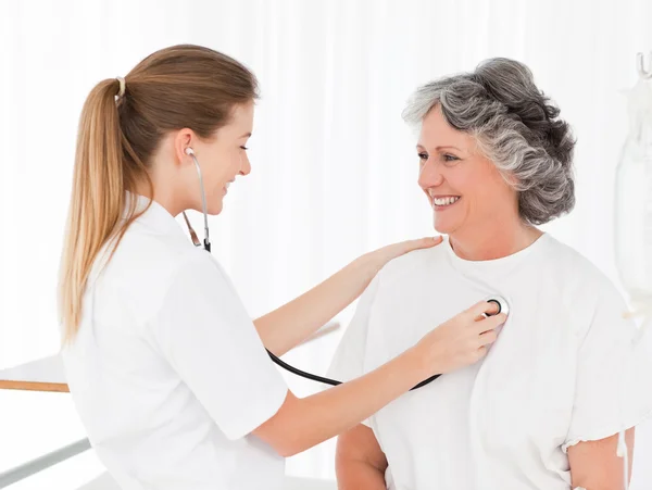 Sjuksköterska tar hjärtslag av hennes patient — Stockfoto