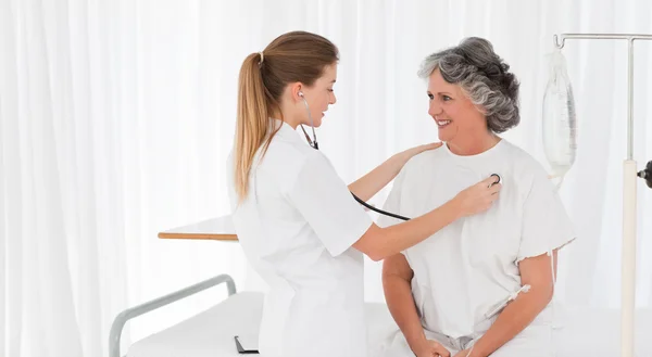 Медсестра принимает сердцебиение своего пациента — стоковое фото