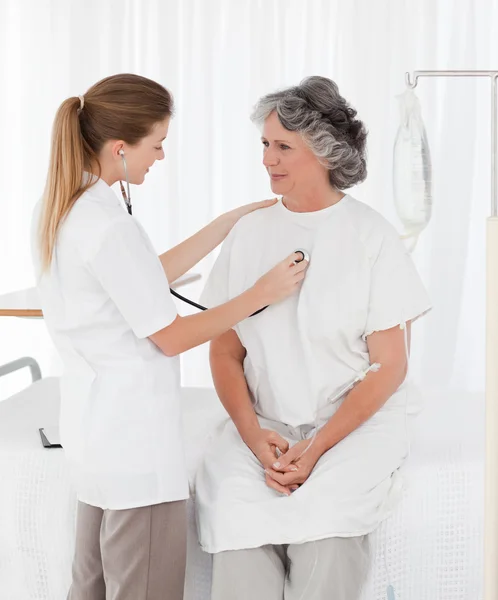 Enfermeira tomando o batimento cardíaco de seu paciente — Fotografia de Stock