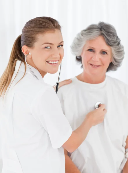 Retired patient with her nurse looking at the camera — Stock Photo, Image