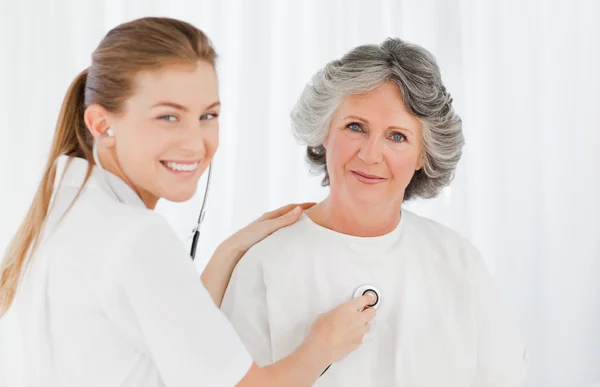 Pensionerad patient med sin sjuksköterska tittar på kameran — Stockfoto