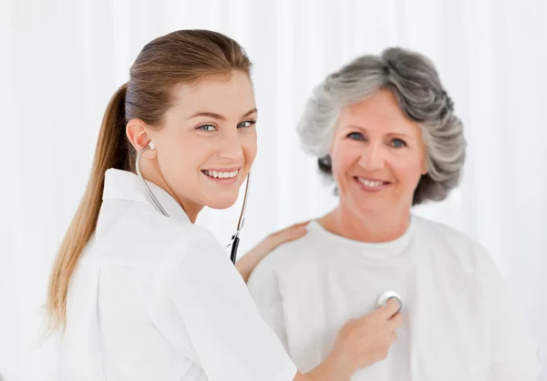 Retired patient with her nurse looking at the camera — Stock Photo, Image