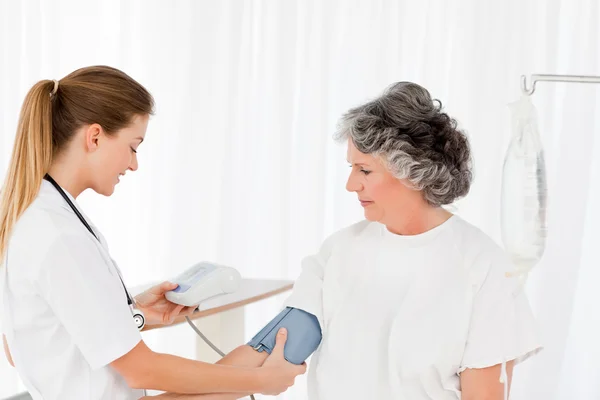 Sjuksköterska tar blodtrycket av hennes patient — Stockfoto
