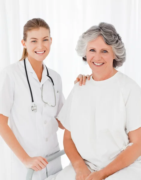 Senior with her nurse looking at the camera — Stock Photo, Image