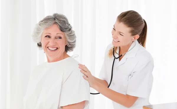 Pretty nurse taking the heartbeat of her patient — Stock Photo, Image