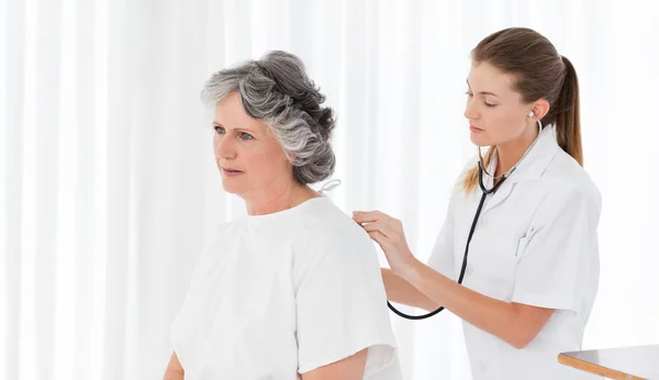 Pretty nurse taking the heartbeat of her patient — Stock Photo, Image