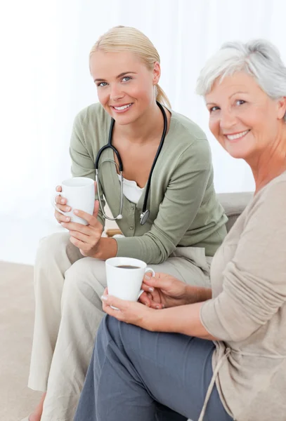 Doctor drinking with her patient — Stock Photo, Image