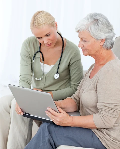 Seniorin arbeitet mit ihrem Arzt am Laptop — Stockfoto