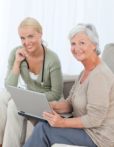 Senior met haar arts werkzaam op de laptop — Stockfoto