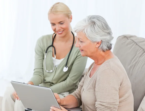 Senior met haar arts werkzaam op de laptop — Stockfoto