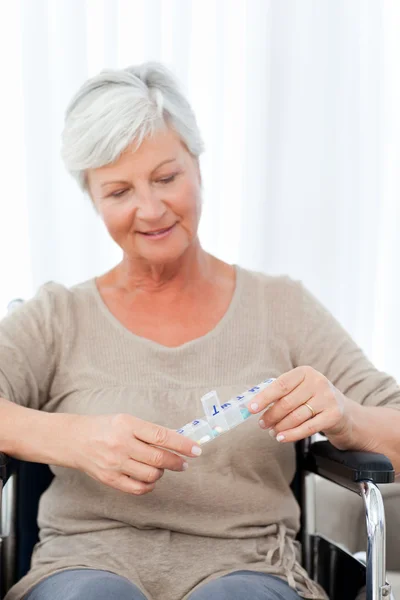 Senior in wheelchair with pills — Stock Photo, Image