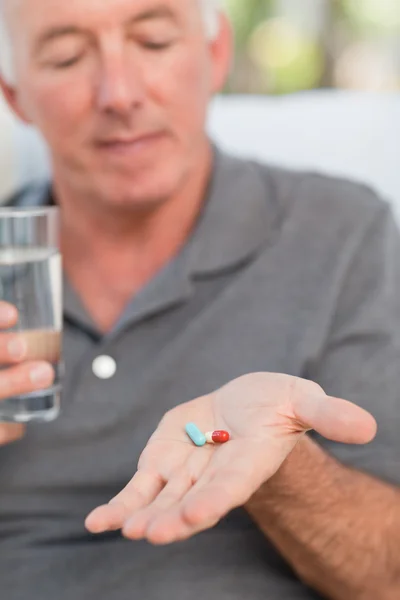 Retired man taking pills — Stock Photo, Image