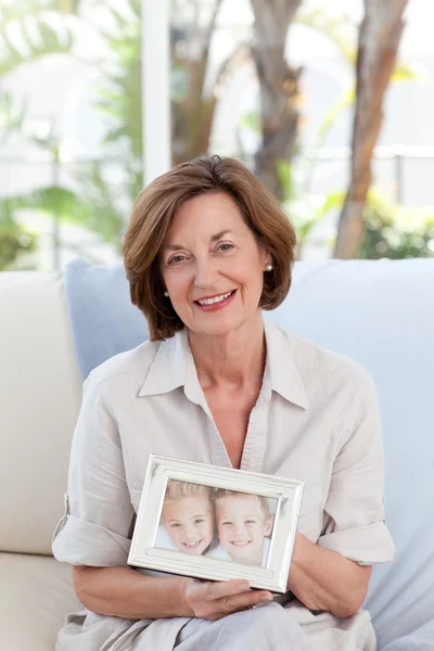 Mujer madura mostrando su foto de su nieto — Foto de Stock