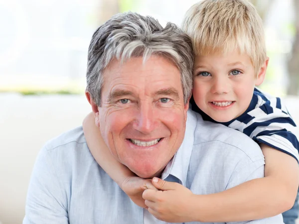 Kleiner Junge mit seinem Großvater, der in die Kamera blickt — Stockfoto