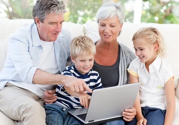 Adorable family looking at their laptop — Stock Photo, Image
