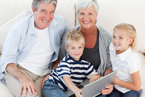 Очаровательная семья смотрит на свой ноутбук — стоковое фото
