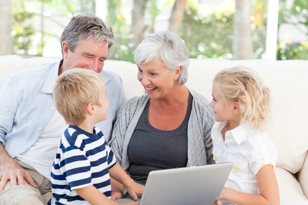 Adorable familia mirando su portátil —  Fotos de Stock