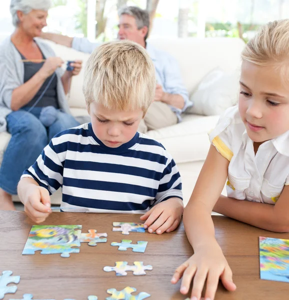 Anak-anak bermain teka-teki di ruang tamu — Stok Foto