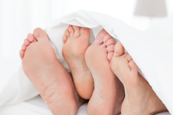 Les pieds de la famille dans le lit — Photo