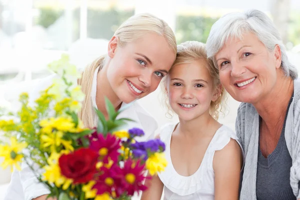 Strahlende Familie mit Blumen — Stockfoto