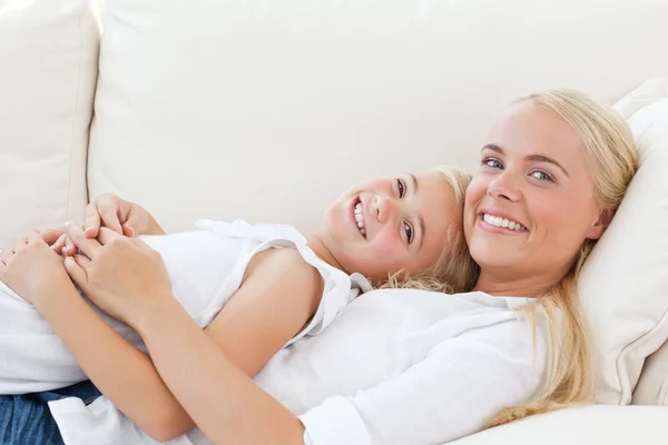 Beautiful woman lying down with her daughter — Stock Photo, Image