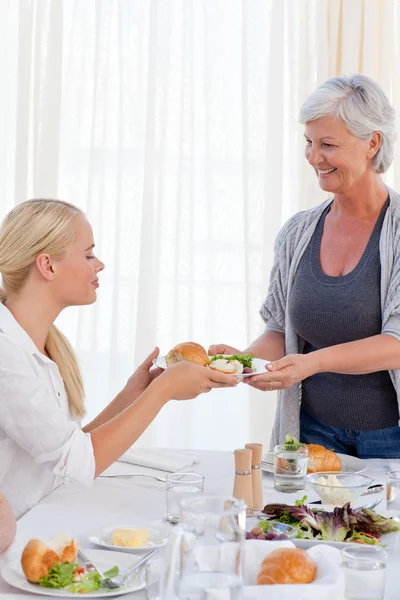 Aged woman serving her daughter — Stock Photo, Image