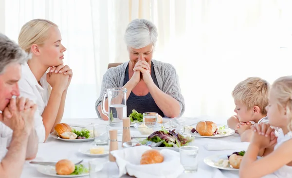 Hübsche Familie betet am Tisch — Stockfoto
