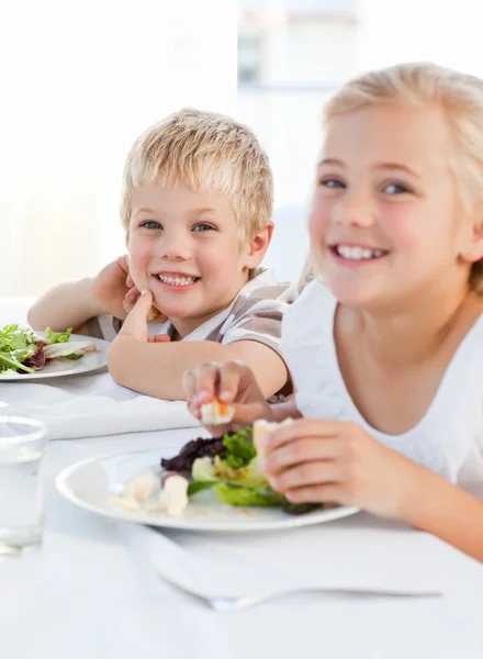 De gelukkige kinderen aan de tafel — Stockfoto