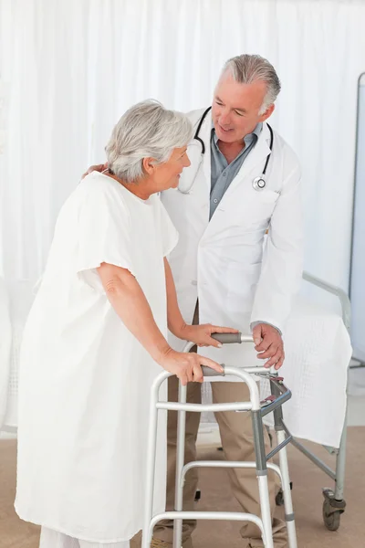 Doctor helping his patient to walk — Stock Photo, Image
