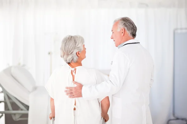 Doctor helping his patient to walk — Stock Photo, Image