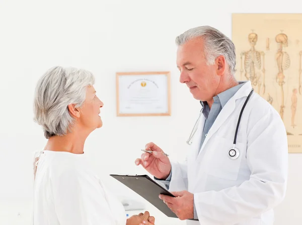 Överläkare talar med sin sjuka patient — Stockfoto